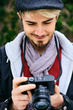 Hipster Street Photographer Reviewing Pictures On Mirrorless Camera Display