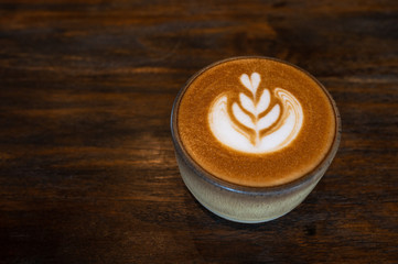 A cup of latte art coffee on wooden table