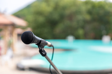 Microphone outdoor near Swimming pools soft and blur style for background. Microphone over the Abstract blurred photo of conference hall or seminar room background.