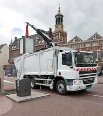 Waste transport. Collecting waste with a truck and crane. Lifting a waste bin. Garbage truck....