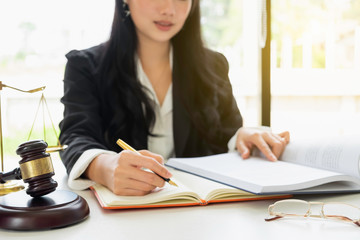 Justice and law concept. Gavel on sounding block in hand's Male judge at a courtroom, working with document law books, report the case on table in modern office.