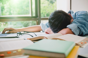 High school or college sleep while sitting at table. Group students studying and reading with books...