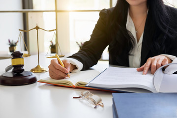 Justice and law concept. Gavel on sounding block in hand's Male judge at a courtroom, working with document law books, report the case on table in modern office.
