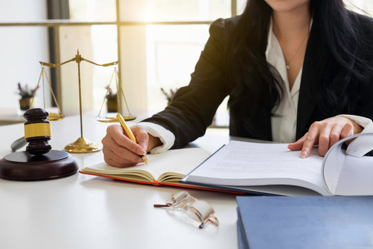 Justice and law concept. Gavel on sounding block in hand's Male judge at a courtroom, working with document law books, report the case on table in modern office.