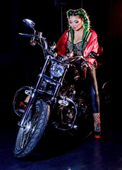 Fototapeta na wymiar Donna in sella a una moto