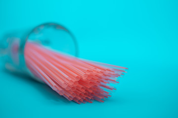 Disposable plastic drinking straws on blue background