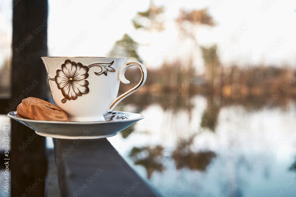 Wall mural cup with saucer and cookies on the background of nature