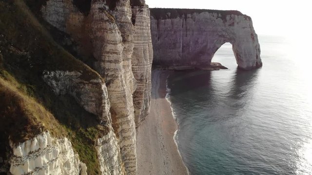 View from drone of the beautiful chalk cliffs and arches of Etretat, France. Coastline of Normandy in the evening