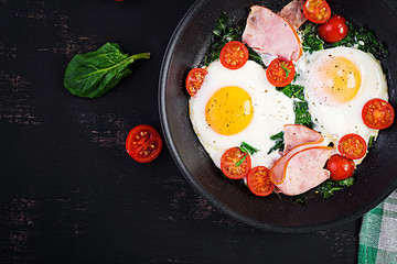 Plate with a keto diet food. Fried egg, ham, spinach, and tomatoes. Keto, paleo breakfast. Top view, copy space