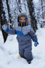 Fototapeta na wymiar happy toddler playing with snow in winter Park