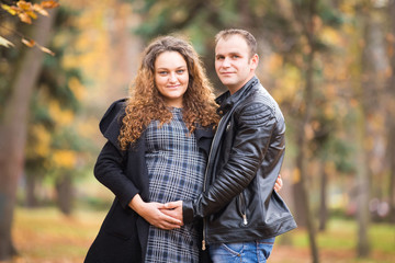 Happy pregnant couple  in autumn background
