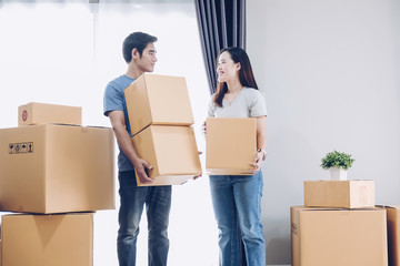 Happy young couple is having fun with cardboard box at new home.Moving house.