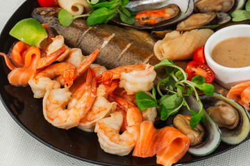  Mixed Seafood Contain Mussels, prawns, salmon, Calamari Squids and Grilled Barracuda Fish Garlic with Spicy Chili Sauce. Isolated on White Background. Seafood and meat platter.   Horizontal
