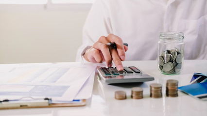 asian man working with calculator to calculate numbers. expenses calculator, payments costs with...