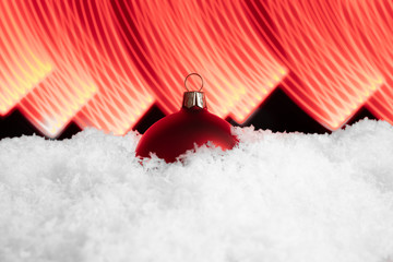 Czerwona bombka Bożonarodzeniowa na śniegu