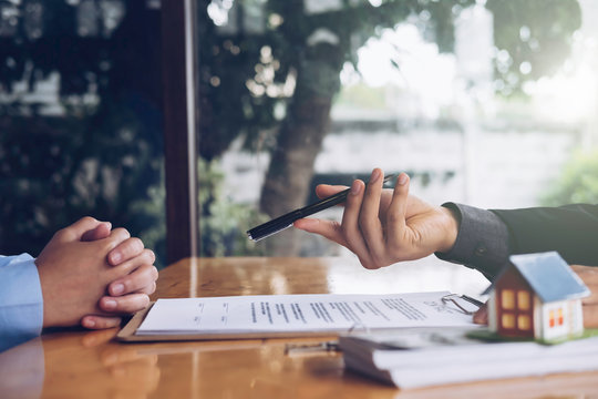 real estate agent holding house key to his client after signing contract,concept for real estate, moving home or renting property
