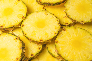 Pineapple juicy yellow slices background. Top view.