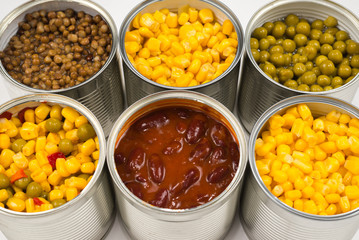 Canned food on white background. Green pea, beans, corn, lentils.