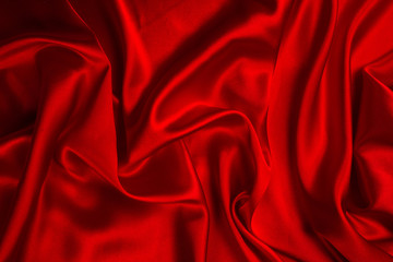 Red silk or satin luxury fabric texture can use as abstract background. Top view.