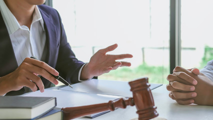 Justice lawyer meeting with contract papers and Judge gavel on tabel in courtroom. Attorney working...
