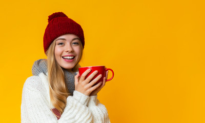 Portrait of pretty winter girl holding red mug