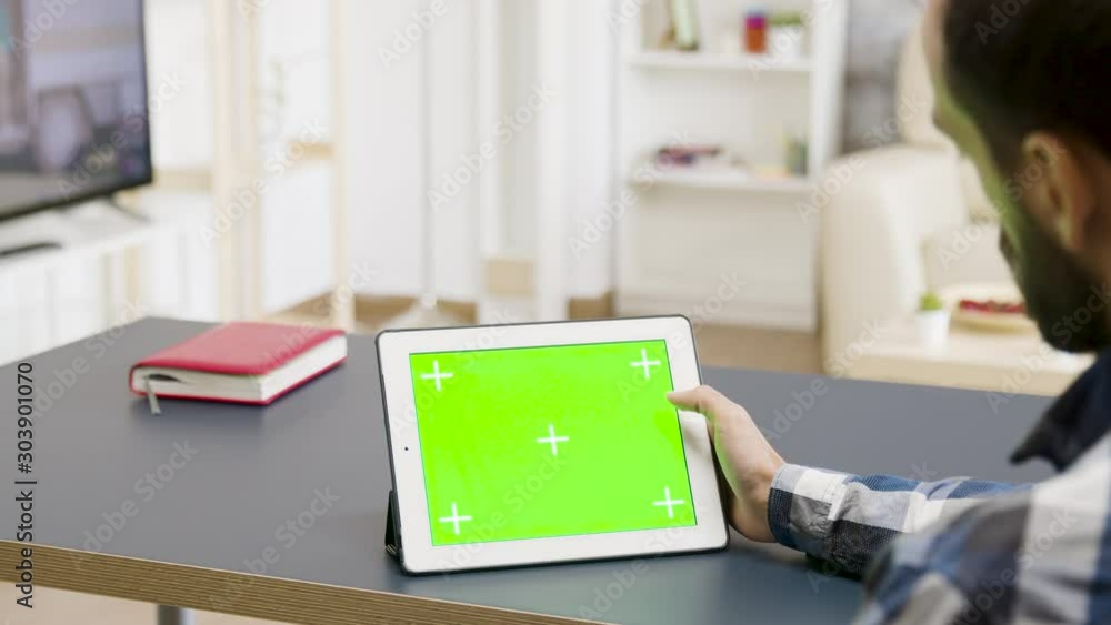 Poster man scrolling and touching a green screen of a digital tablet
