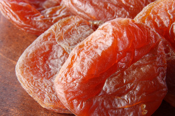 Bright red dried apricot on a brown background