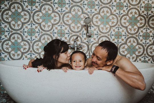 Happy Family With Little Daughter Take A Bath In Bathtub