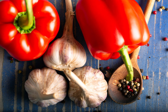 red peppers garlic and pepper on a wooden table