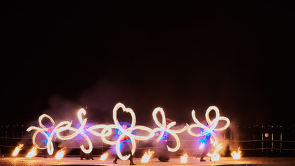 Artists juggling with burning poi's at fire performance.