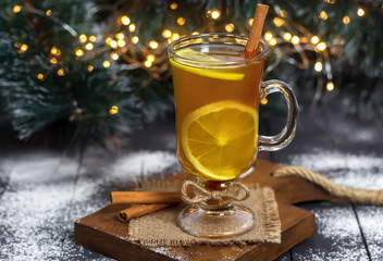 New Year, Christmas drink. Glass of Hot Toddy on wooden table decorated with Christmas tree and...