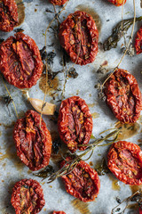 tomatoes on baking sheet, aromatic herbs, thyme, basic, garlic, olive oil, top view