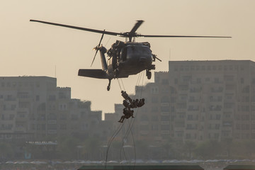 Military combat and war with helicopter flying into the chaos and destruction. Soliders suspend...