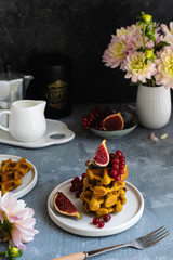 Dark still life, breakfast waffles, fresh figues, red