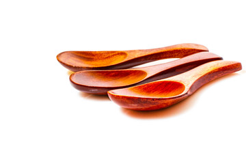 Three wooden spoons on a white background made of natural mahogany.