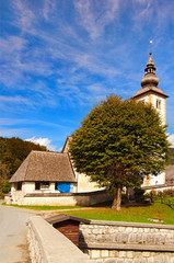 Fototapeta na wymiar Picturesque landscape view of medieval John the Baptist Church near Bohinj Lake against vibrant blue sky. Bohinj Lake, Triglav National Park, Slovenia. Concept of landscape and nature