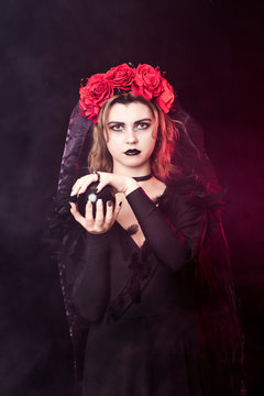 girl witch in a wreath of red roses