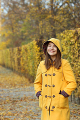 happy girl in a yellow hooded coat in the park portrait Augarten Vienna