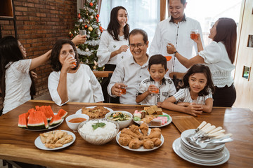 family cheering during lunch together at home on christmas celebration day