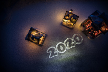 New Year miniature house in the snow at night with fir tree.