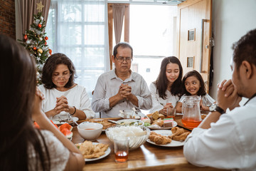 people praying before having their lunch. christian family pray