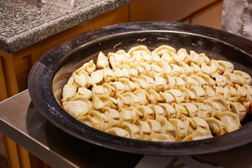 big frying pan with sheng jian bao-traditional chinese pan fried dumplings with minced pork shrimp and vegetables in Shanghai China, Cantonese food,pan-fried