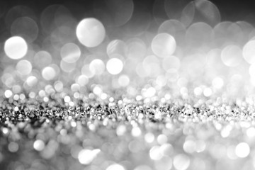 Silver Sparkling Lights Festive background with texture. Abstract Christmas twinkled bright bokeh defocused and Falling stars. Winter Card or invitation	