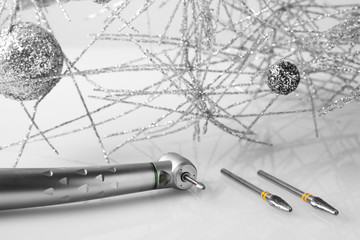 Stainless steel high speed dental hand piece with tiny grinding wheel and medical parts and christmas decorations.
