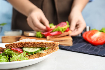 Obraz na płótnie Canvas Tasty sandwich on light grey table, closeup