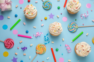Flat lay composition with cupcakes on light blue background. Birthday party
