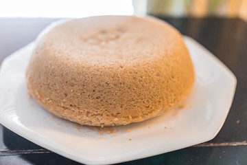 Small plain yellow vanilla homemade sponge birthday cake on white plate cooking preparation made with gluten free flour