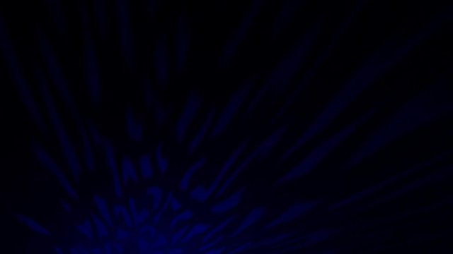 Beautiful oriental highlight flares moving over dark colour background. Mystic ornate light shifting on blue backdrop. Shade pattern created by a candle lantern.
