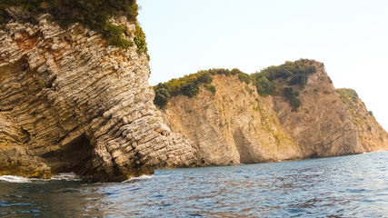 Fototapeta na wymiar The rocks over the transparent ocean water. Montenegro. Rafailovici.