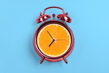 Red Alarm Clock With Orange- Time Concept and light blue background